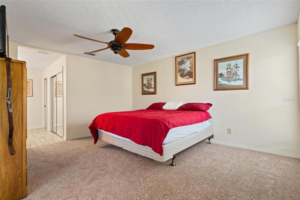 1801 East Lake Road South, Unit 4E Palm Harbor, FL 34685 - Photo 19 of 26 a bedroom with a bed and painting on the wall