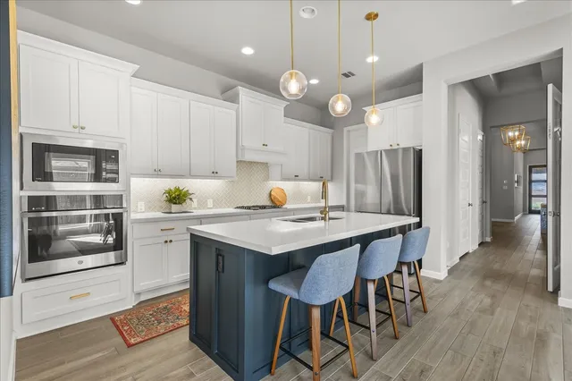 a kitchen with a sink stainless steel appliances and wooden cabinets