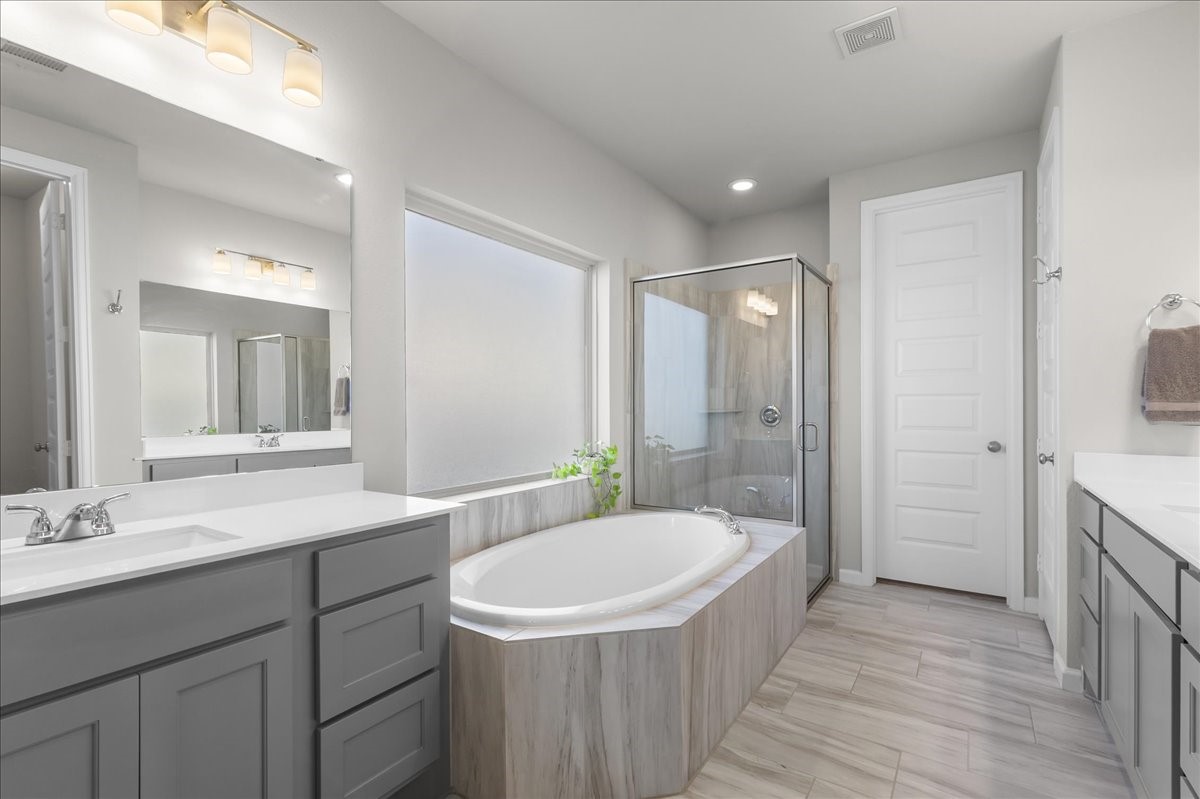 4910 Morrison Drive Manvel, TX 77578 - Photo 11 of 35 a bathroom with a bathtub a sink a mirror a shower and vanity