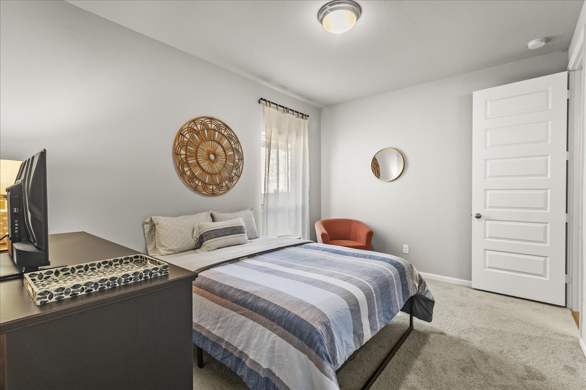 4910 Morrison Drive Manvel, TX 77578 - Photo 24 of 35 a bedroom with a bed and a chandelier