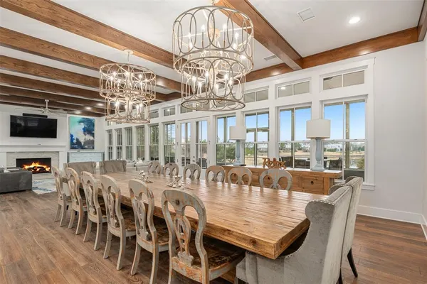 a view of a dining room with furniture a chandelier and wooden floor