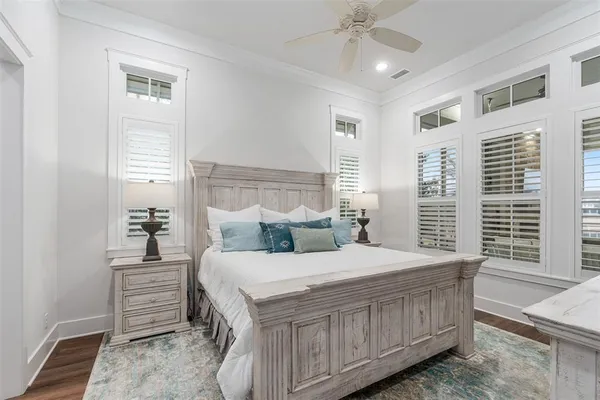 a bedroom with a bed a ceiling fan and a dresser
