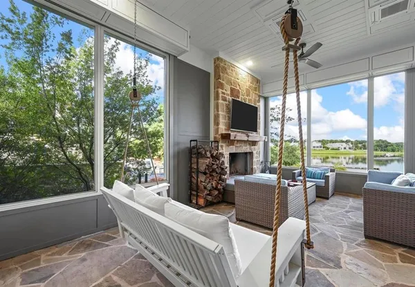 a living room with furniture a flat screen tv and a floor to ceiling window