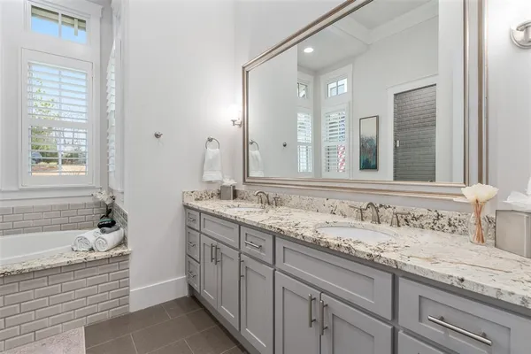 a bathroom with a tub sink and mirror