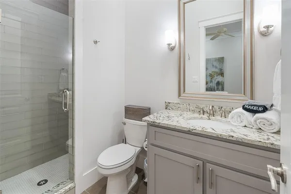 a bathroom with a granite countertop toilet a sink and a mirror