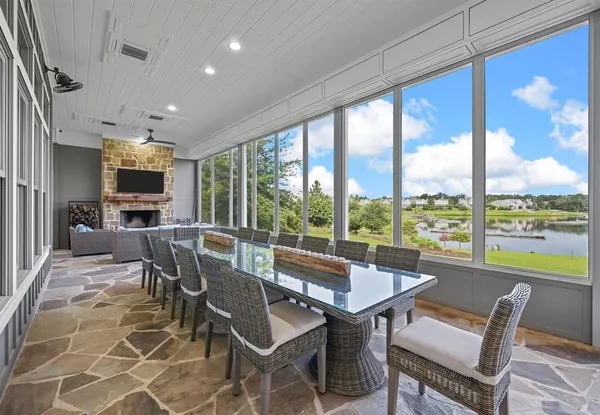 a view of a dining room with furniture large windows and wooden floor