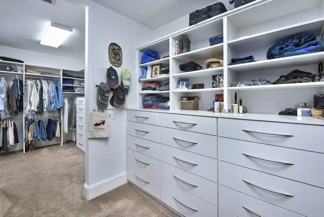 a view of walk in closet with clothes and shoes