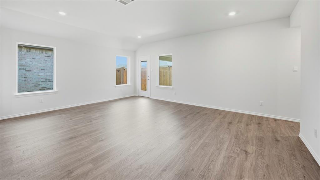 505 Yellow Rose Way Princeton, TX 75407 - Photo 31 of 35 an empty room with wooden floor and windows