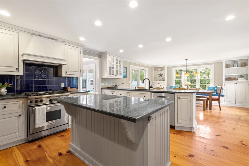 2 Yorkshire Road Dover, MA 02030 - Photo 12 of 42 a large kitchen with granite countertop a stove top oven a sink a dining table and chairs with wooden floor