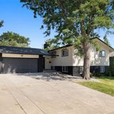 a view of a house with a yard and tree