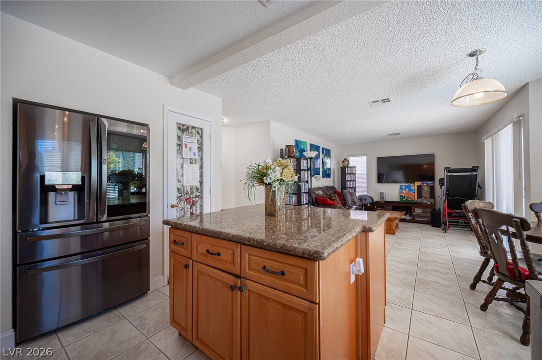 718 Rusty Spur Drive Henderson, NV 89014 - Photo 19 of 50 A well-appointed kitchen island with granite counters separates the cooking space from the inviting living area.