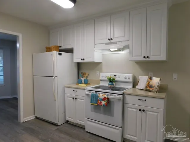a kitchen with refrigerator cabinets and wooden floor
