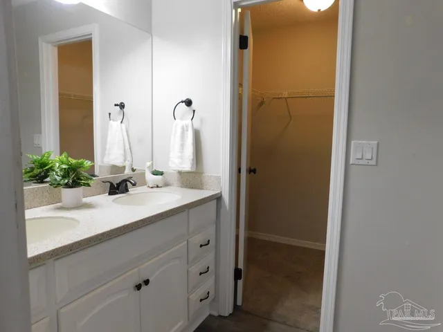 a bathroom with a granite countertop sink a mirror and a shower