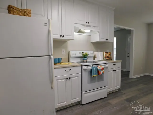 a kitchen with stainless steel appliances white cabinets and a refrigerator