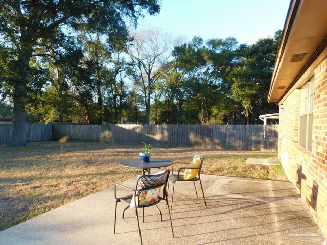 a view of backyard with swimming pool and seating space