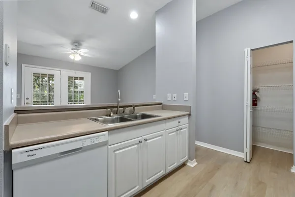 a kitchen with white cabinets and white appliances