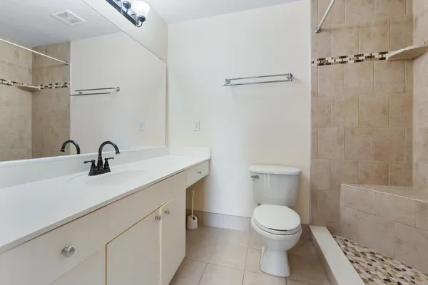 a white toilet sitting next to a shower