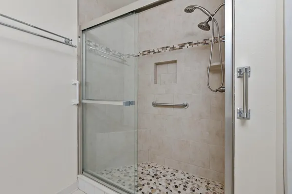 a bathroom with a sink a toilet a mirror and shower