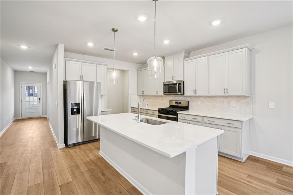 6939 Winchester Place Fairburn, GA 30213 - Photo 14 of 56 a kitchen with stainless steel appliances a refrigerator and a stove top oven