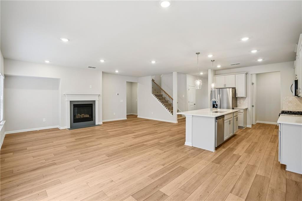6939 Winchester Place Fairburn, GA 30213 - Photo 15 of 56 a view of kitchen with kitchen island wooden floor and living room