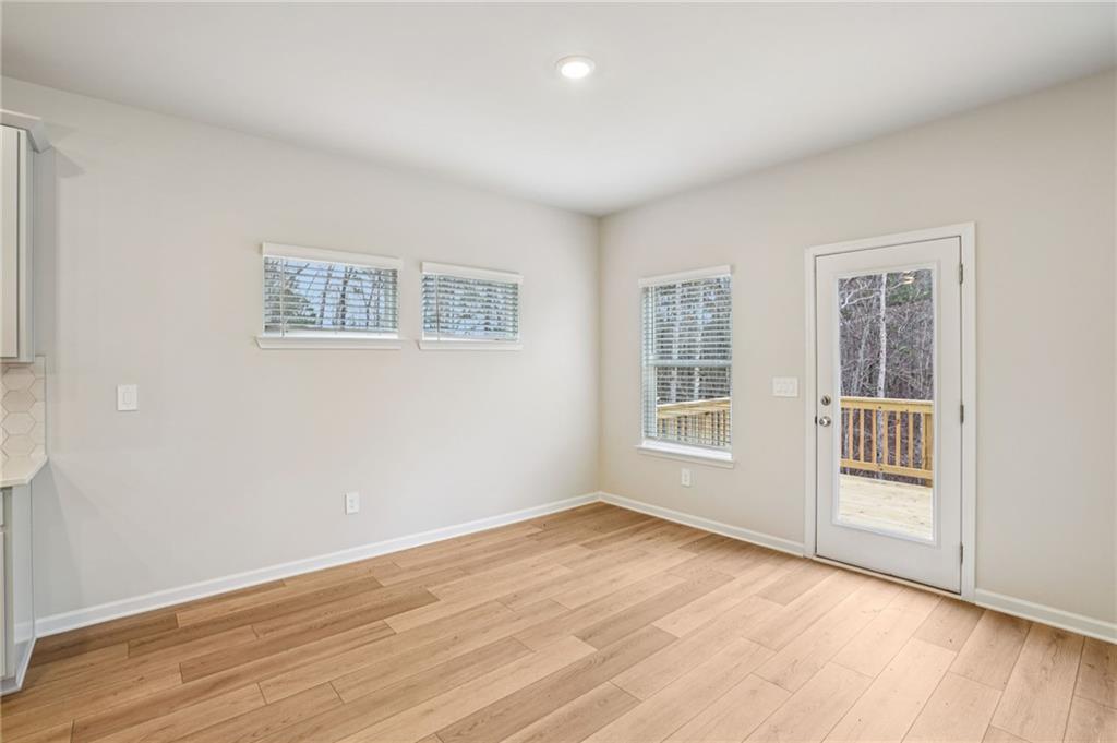 6939 Winchester Place Fairburn, GA 30213 - Photo 21 of 56 a view of an empty room with wooden floor and a window