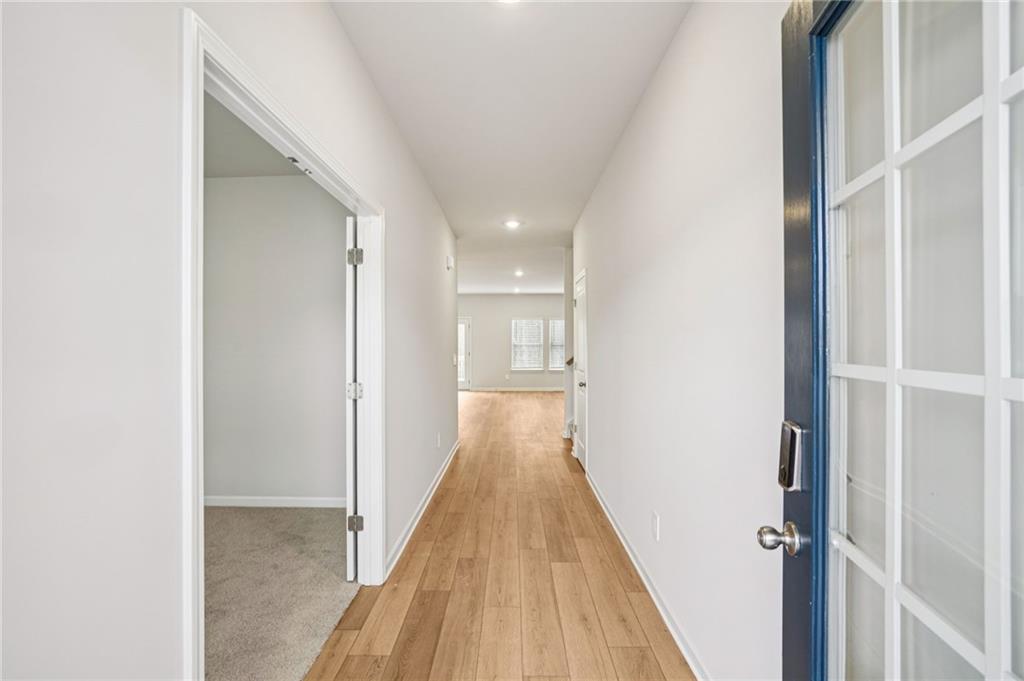 6939 Winchester Place Fairburn, GA 30213 - Photo 6 of 56 a view of a hallway with wooden floor and staircase