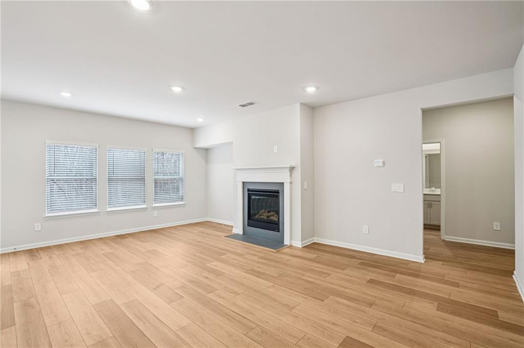 6939 Winchester Place Fairburn, GA 30213 - Photo 7 of 56 a view of an empty room with wooden floor fireplace and a window