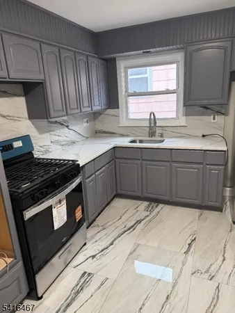 a kitchen with stainless steel appliances granite countertop wooden cabinets a stove a sink and a window