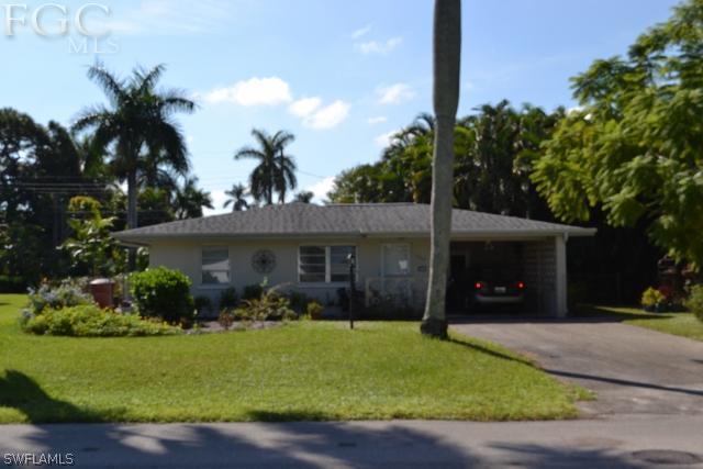 a front view of a house with a yard and potted plants