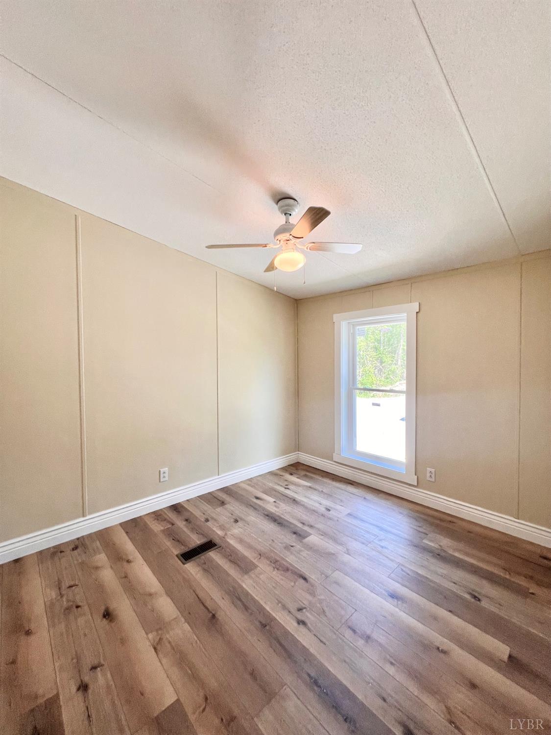2107 Boxwood Farm Road Amherst, VA 24521 - Photo 6 of 33 a view of empty room with wooden floor and fan