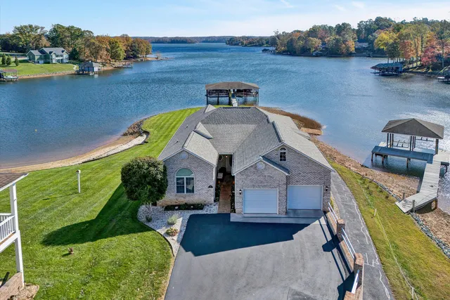 a view of a house with a yard and large tree