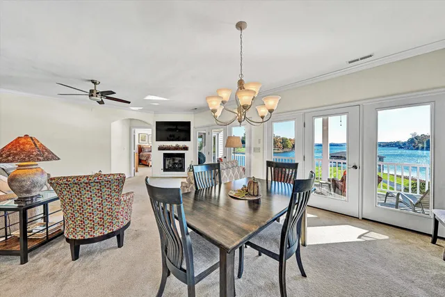 a dining room with furniture a chandelier and glass door