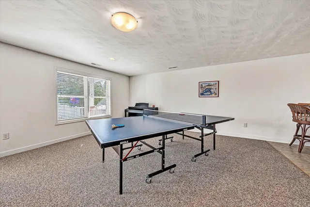a view of a white house with a big yard and potted plants