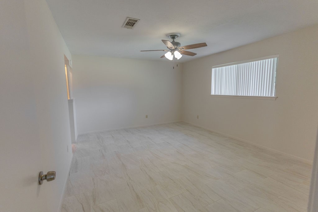9806 Cane Creek Drive Houston, TX 77070 - Photo 17 of 28 an empty room with a window and a ceiling fan