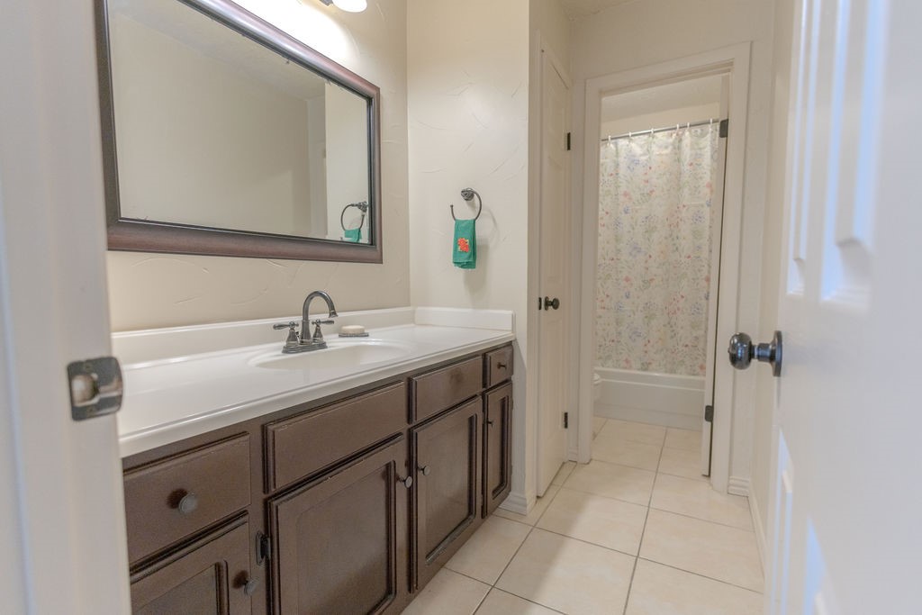 9806 Cane Creek Drive Houston, TX 77070 - Photo 25 of 28 a bathroom with a double vanity sink a mirror and a bathtub