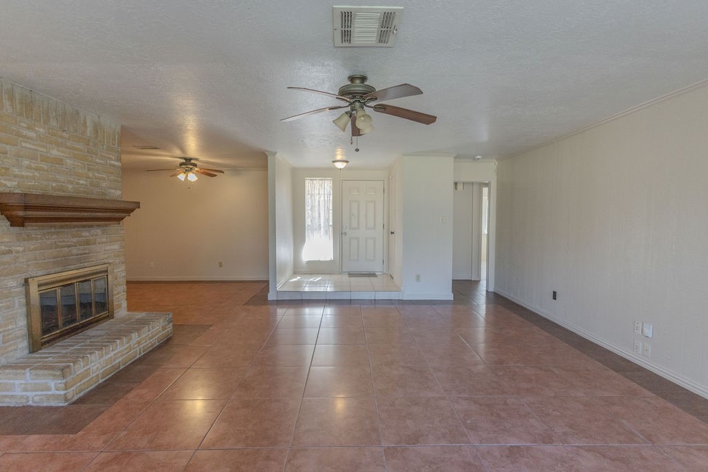 9806 Cane Creek Drive Houston, TX 77070 - Photo 6 of 28 an empty room with wooden floor fireplace and fan