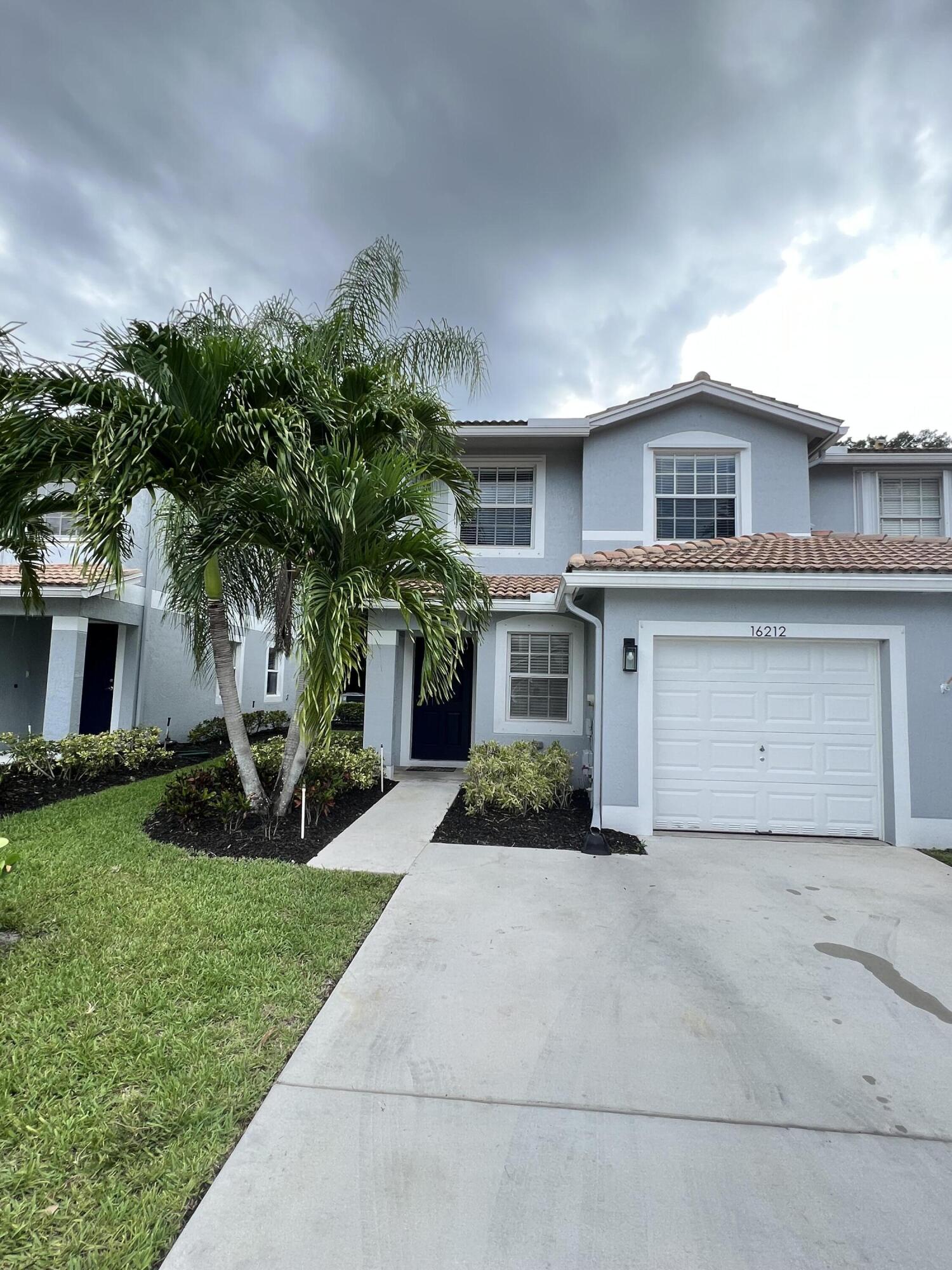 16212 Sierra Palms Drive Delray Beach, FL 33484 - Photo 1 of 16 a front view of a house with a yard and garage