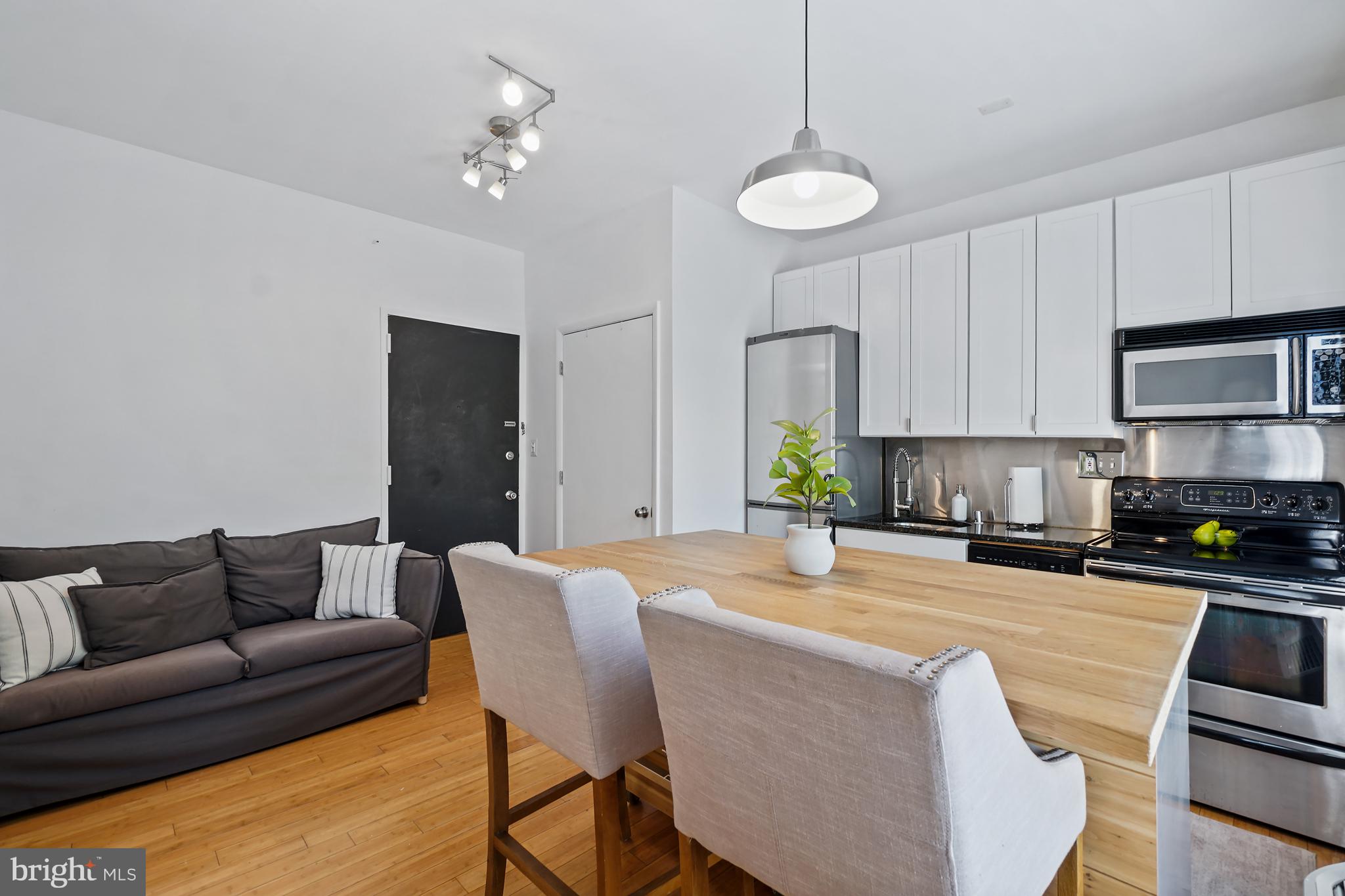 1822 15th Street Northwest, Unit 303 Washington, DC 20009 - Photo 2 of 22 a living room with stainless steel appliances kitchen island granite countertop furniture and a fireplace
