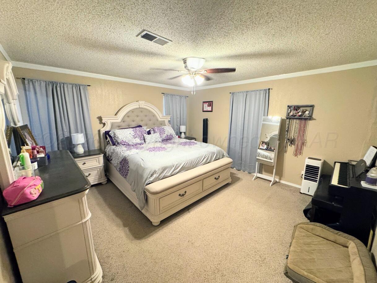 1413 South Harvard Street Perryton, TX 79070 - Photo 11 of 14 a bedroom with a bed couch and a window