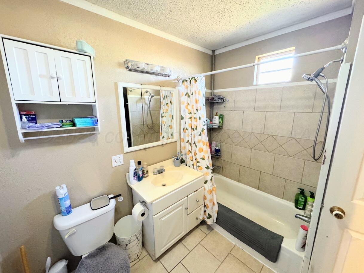1413 South Harvard Street Perryton, TX 79070 - Photo 12 of 14 a bathroom with a sink toilet tub and shower