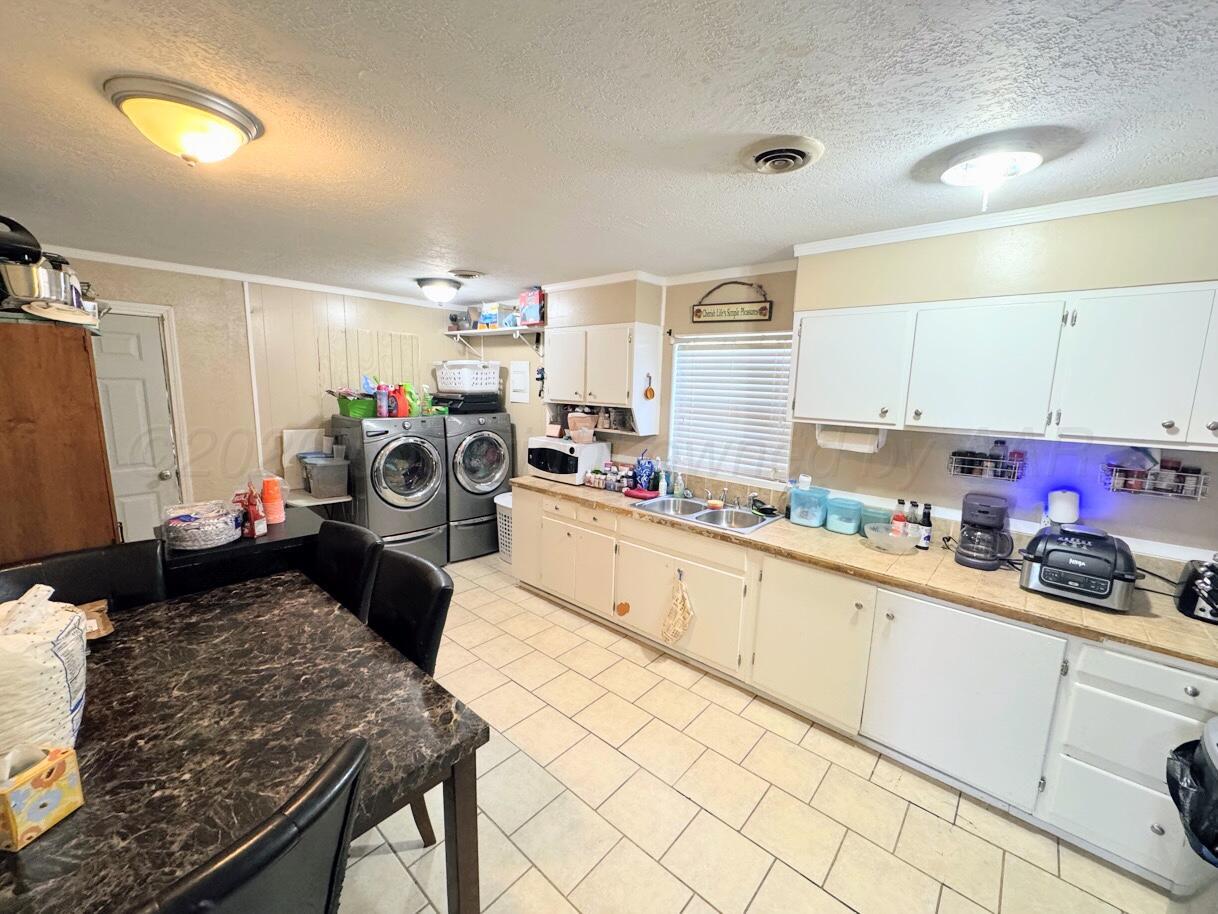 1413 South Harvard Street Perryton, TX 79070 - Photo 3 of 14 a kitchen with a sink stove and cabinets
