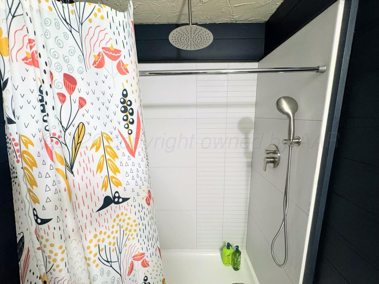 1413 South Harvard Street Perryton, TX 79070 - Photo 8 of 14 a bathroom with a shower curtain and a sink