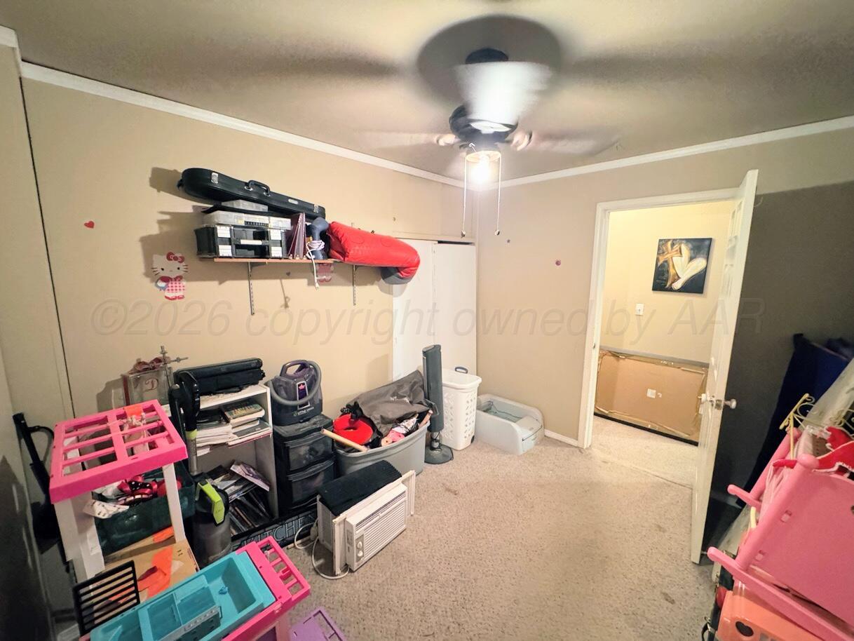 1413 South Harvard Street Perryton, TX 79070 - Photo 10 of 14 a bedroom with furniture and a flat screen tv