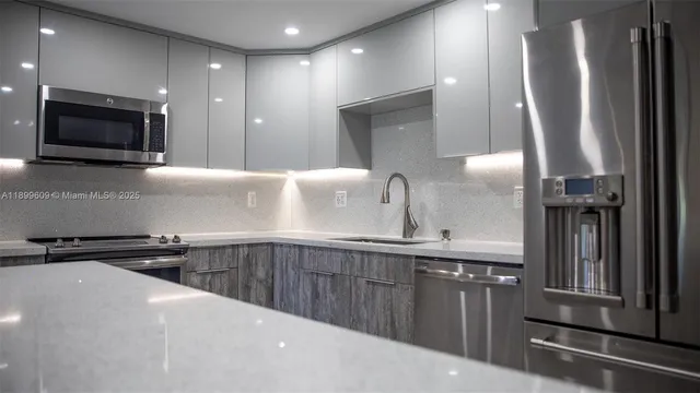 a kitchen with stainless steel appliances a sink and a microwave