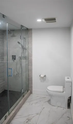 a bathroom with a toilet and a shower