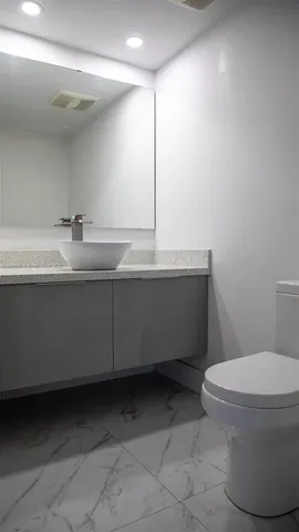 a bathroom with a sink toilet and mirror