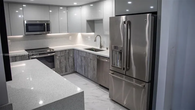a kitchen with stainless steel appliances granite countertop a refrigerator and a stove top oven
