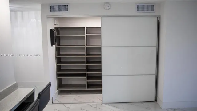 a view of walk in closet with empty racks