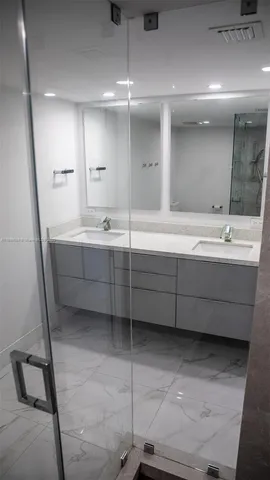 a bathroom with a double vanity sink mirror and bathtub