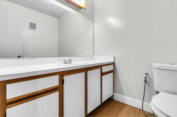 a bathroom with a sink a toilet and a mirror